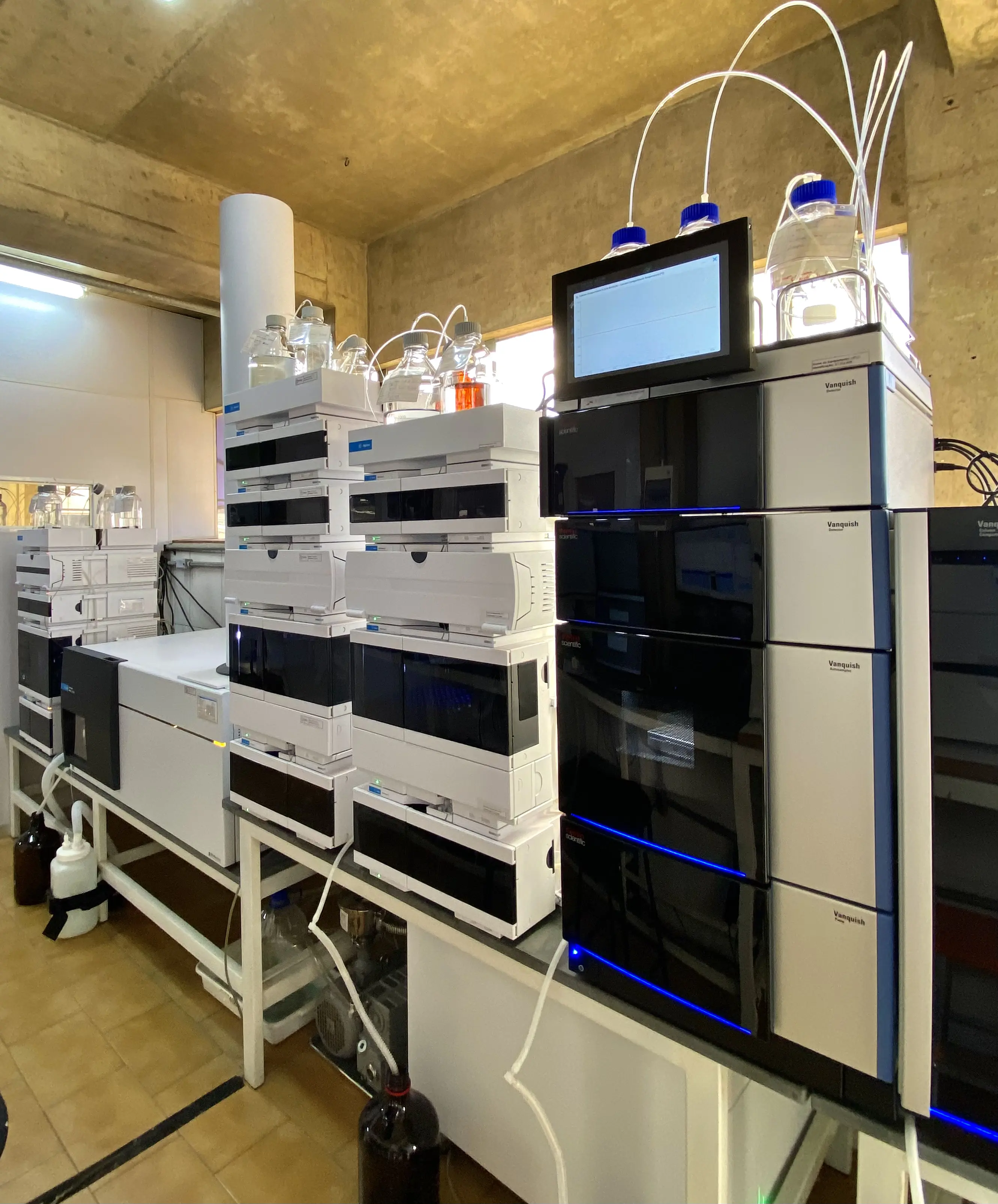 Técnica de laboratório preparando amostras em bancada com vidrarias.